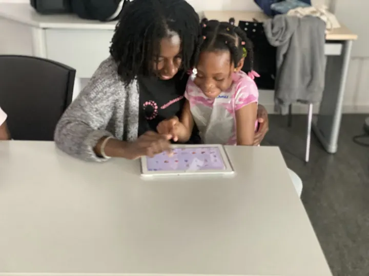 Zwei junge Lernende entdecken eine Programmier-App auf dem Tablet