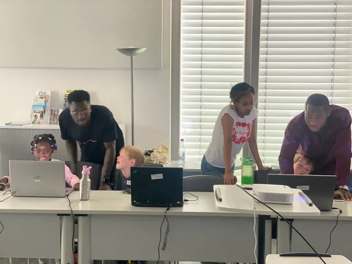 Mentoren helfen Schülern an den Laptops