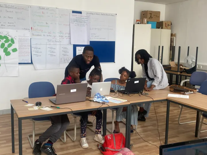 Freiwillige helfen Kindern an ihren Laptops